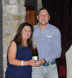 Mary Mcgrath,Falcon Travel receives a bottle of Champagne from Ben Boudin.