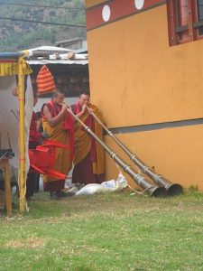 Monks blow dungchen (Tibetan long horns)