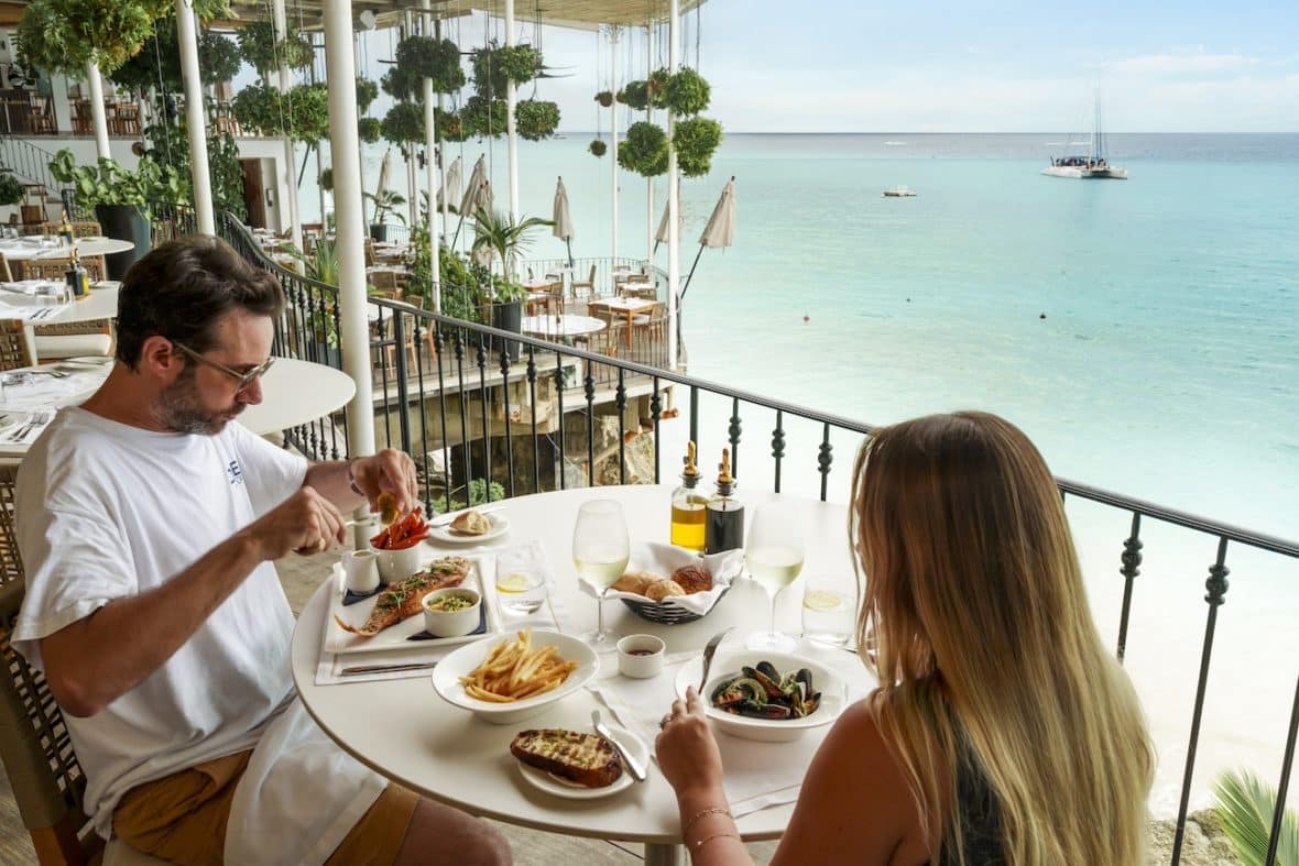 Barbados - Couple enjoying a meal on a balcony by the beach